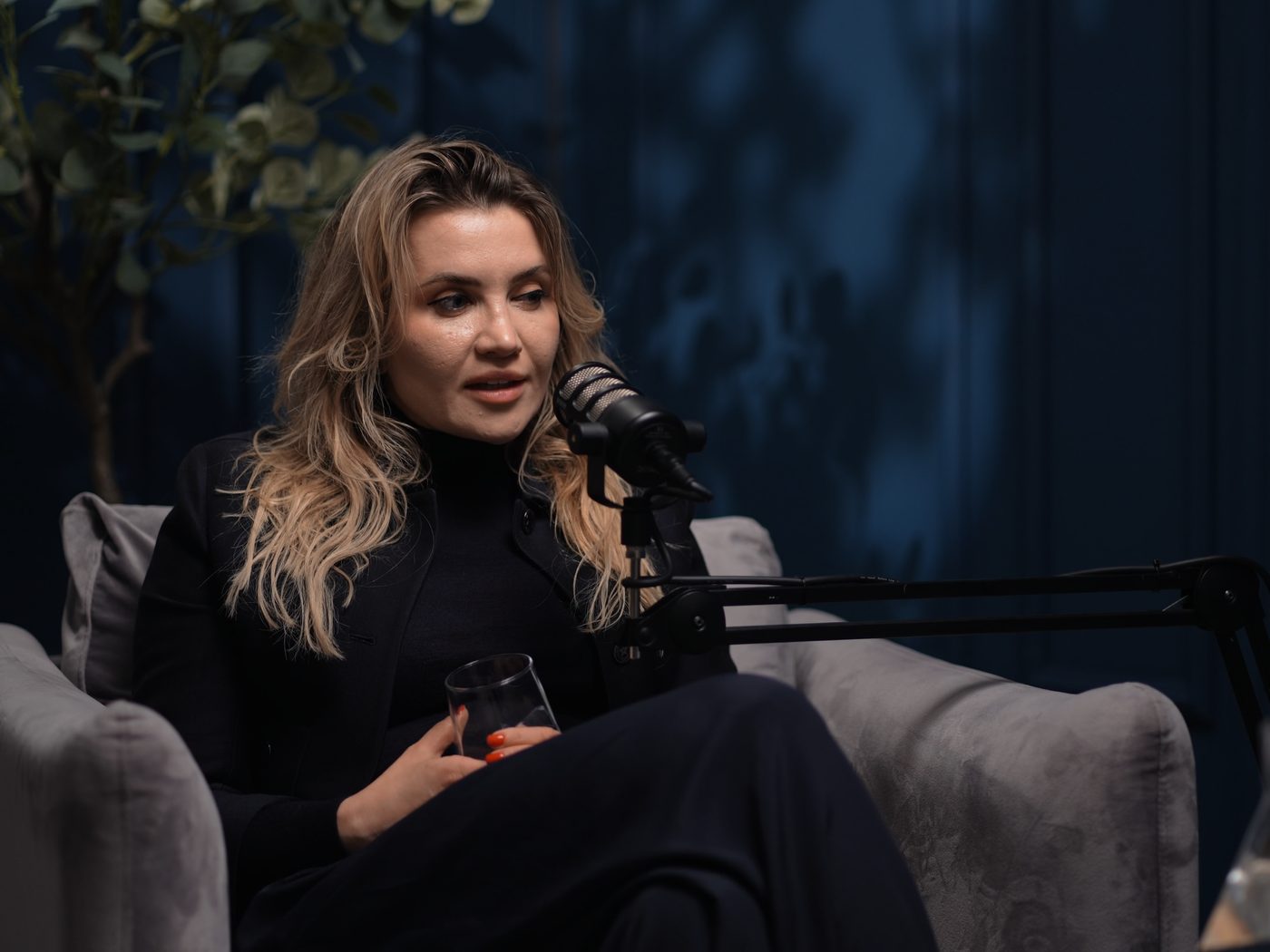 Lenka Zajícová během natáčení Priority Podcastu, studio s tmavě modrou stěnou